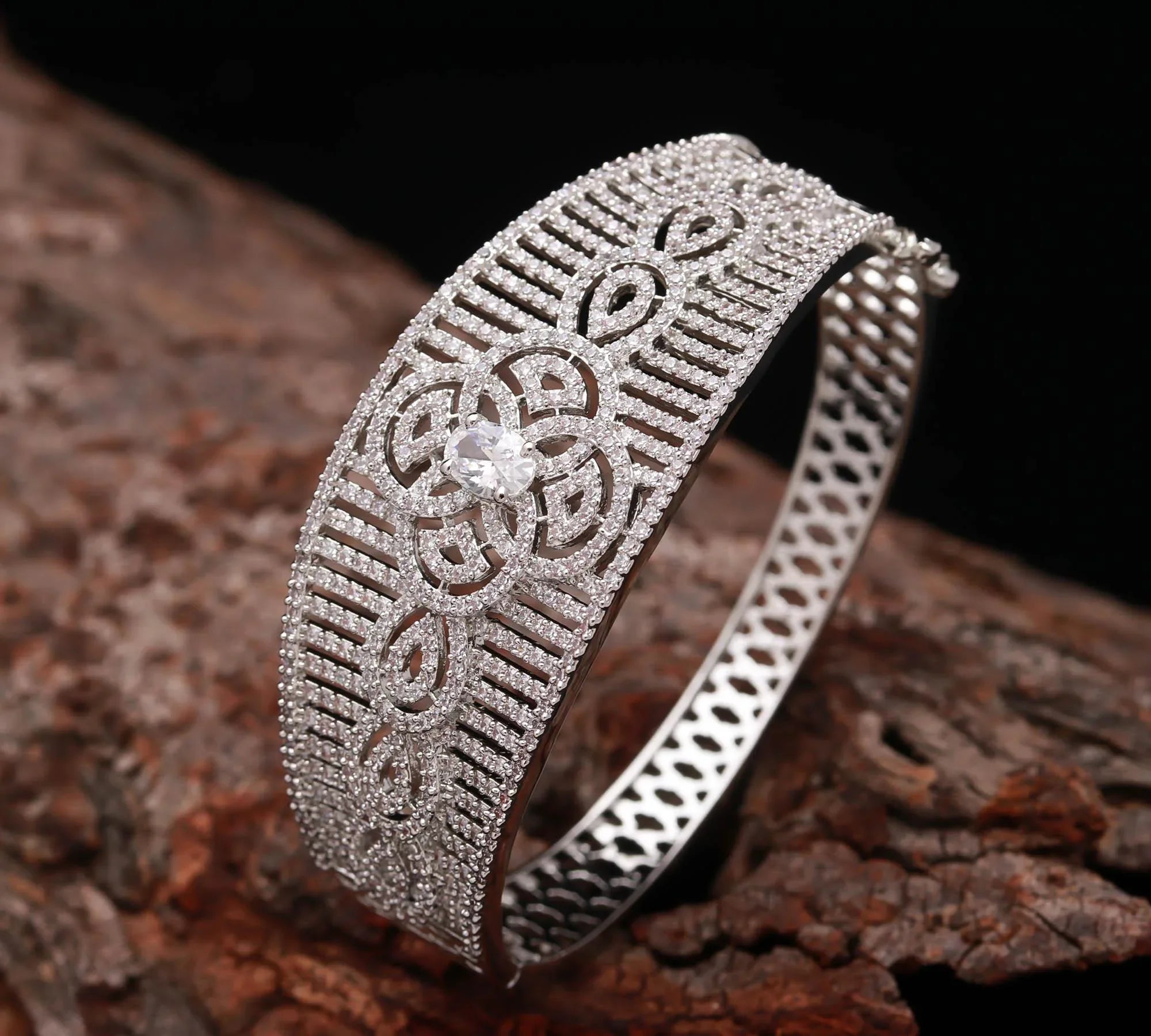 Haamsi silver diamond bracelet with intricate floral design on rustic wood background
