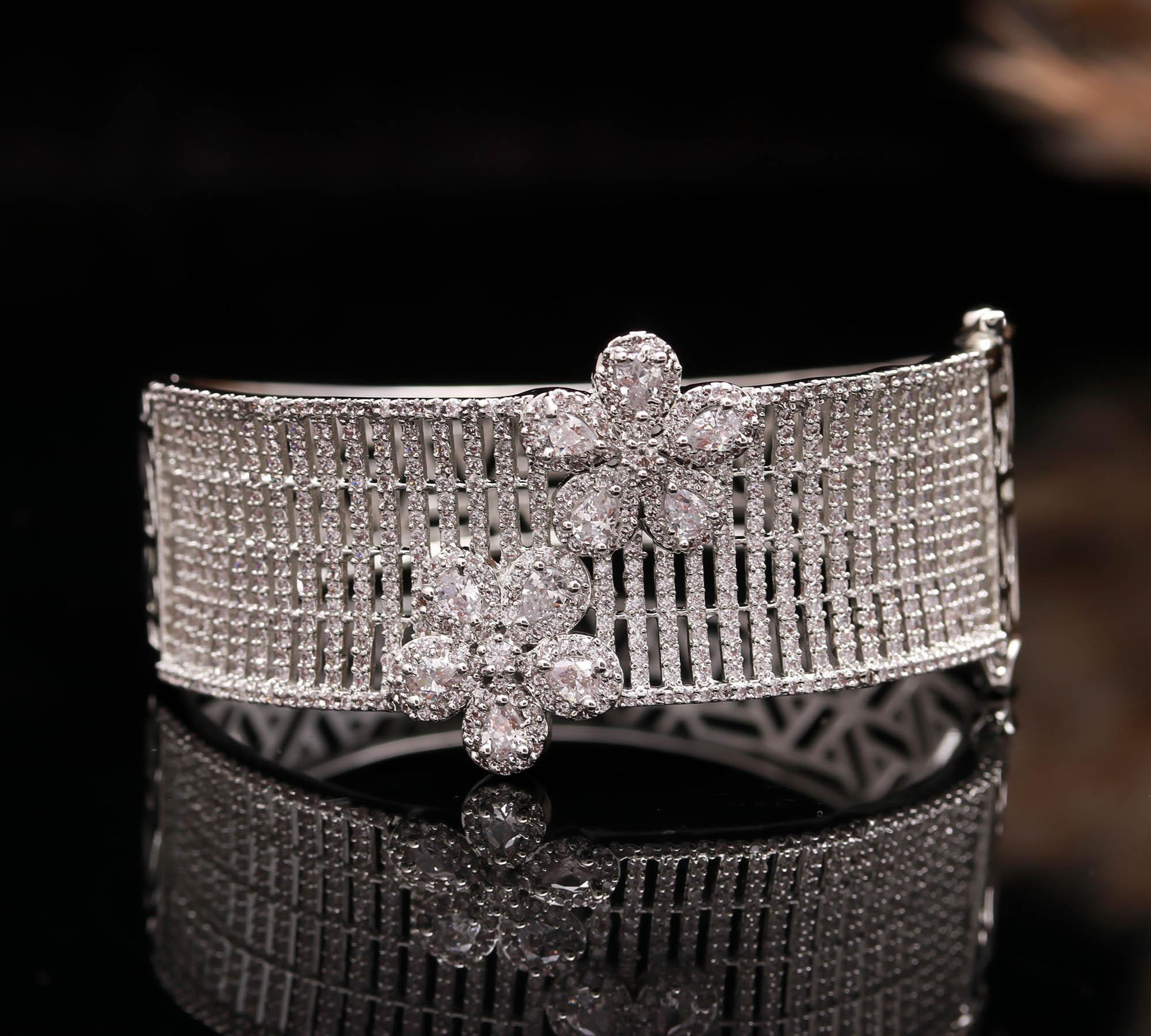 Haamsi silver bracelet with diamond-studded mesh design and two floral clusters on black reflective surface