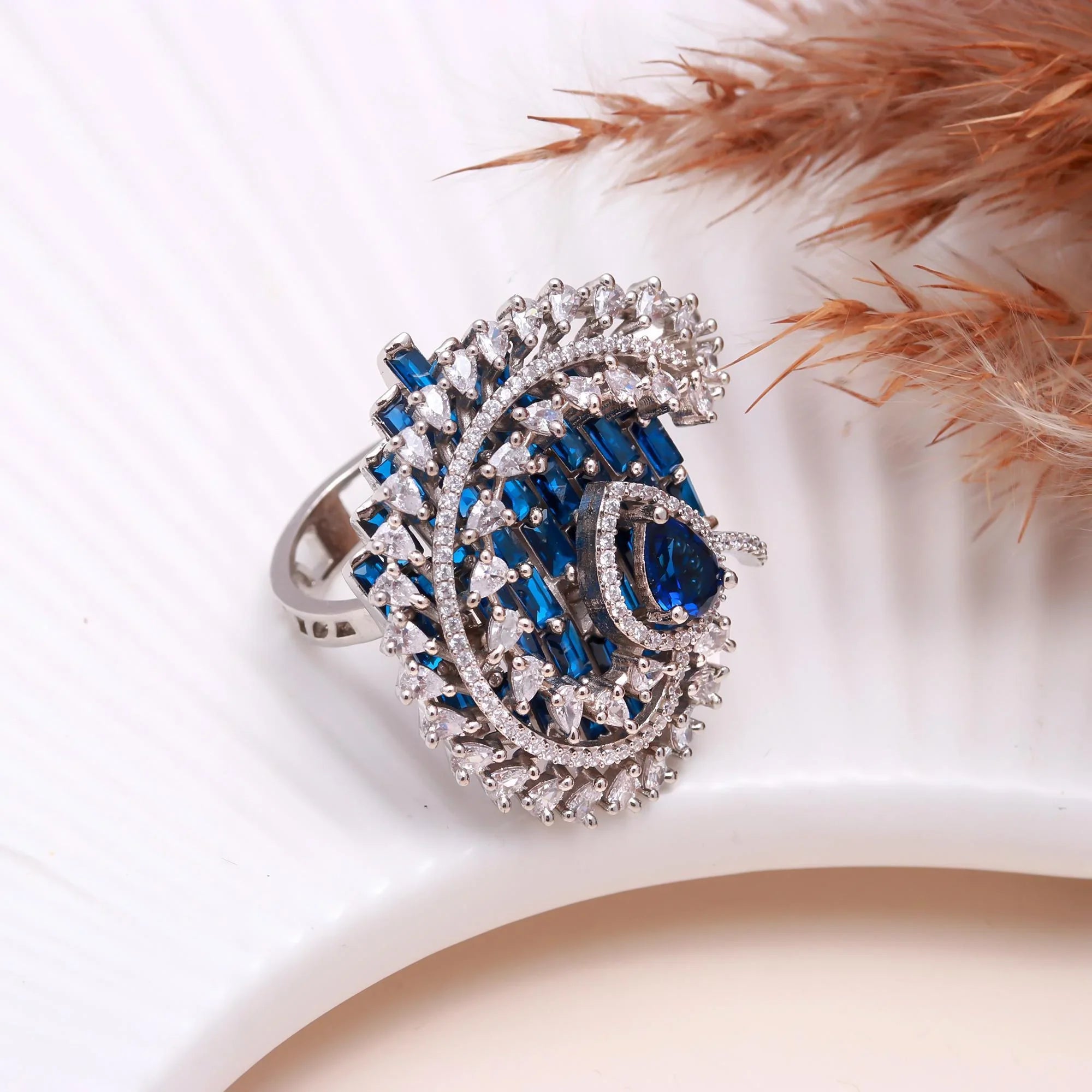 Haamsi silver ring with blue sapphire and white diamond gemstones on white textured surface