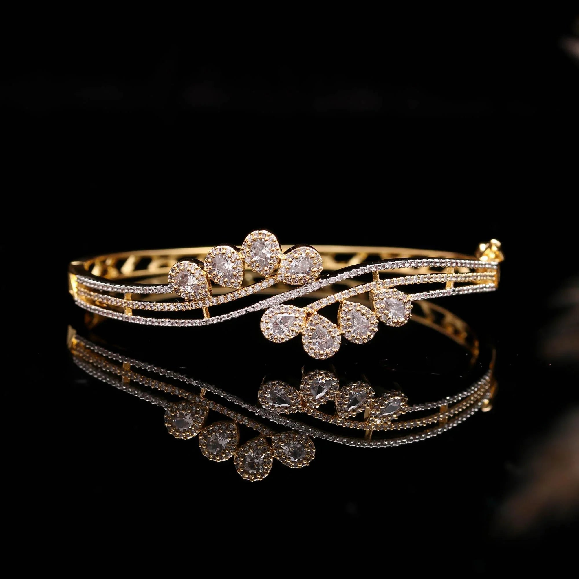 Elegant gold and diamond bracelet with teardrop-shaped stones on black background